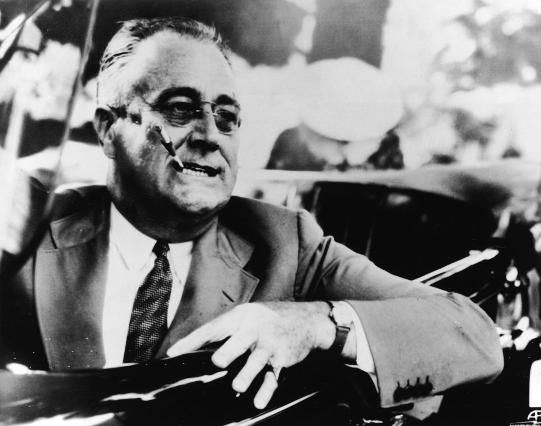 President Franklin Delano Roosevelt smokes a cigarette in a car in Hyde Park, New York, on July 4, 1937. 