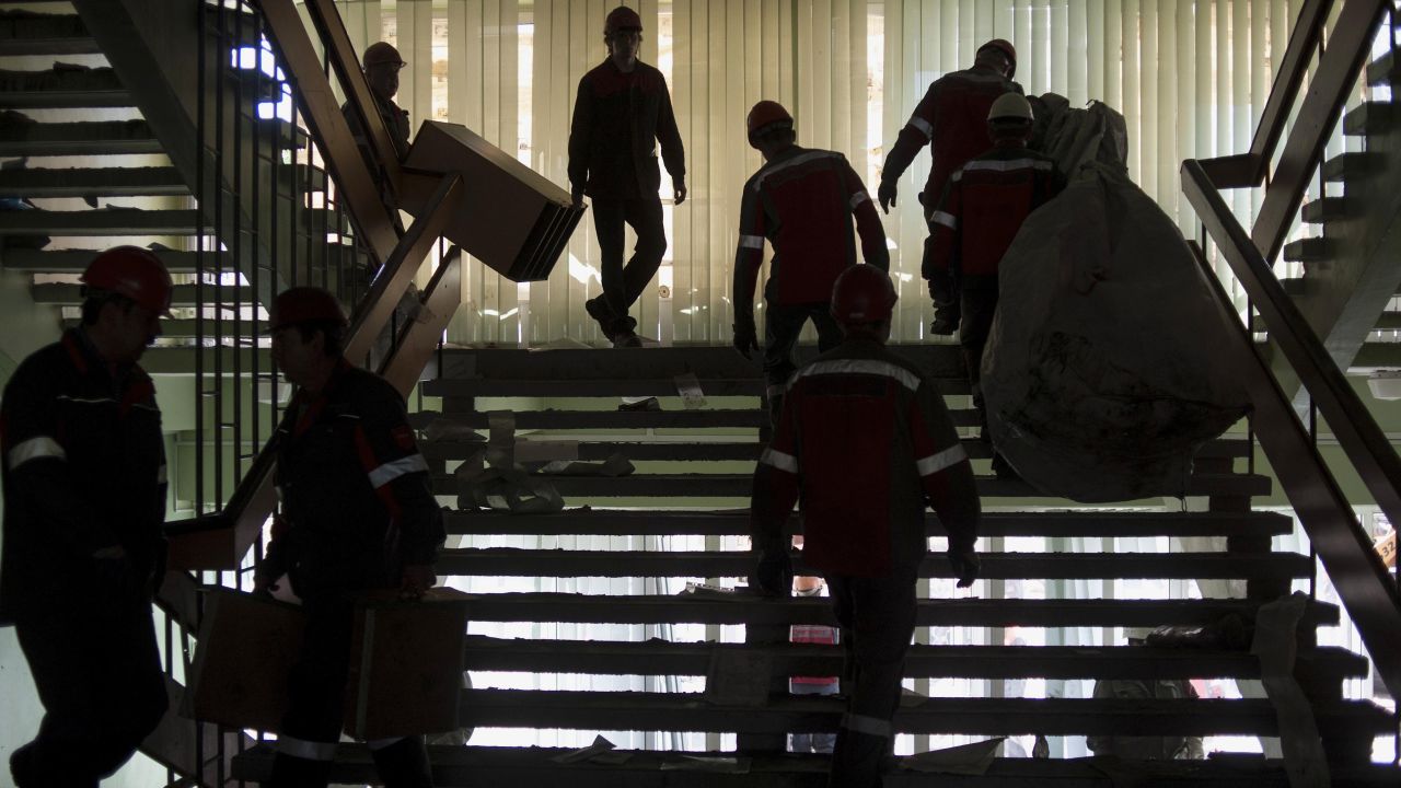 Employees of the Ukrainian company Metinvest clear away debris in a government building in Mariupol, Ukraine, on Friday, May 16, after pro-Russian separatists relinquished their hold on it. 