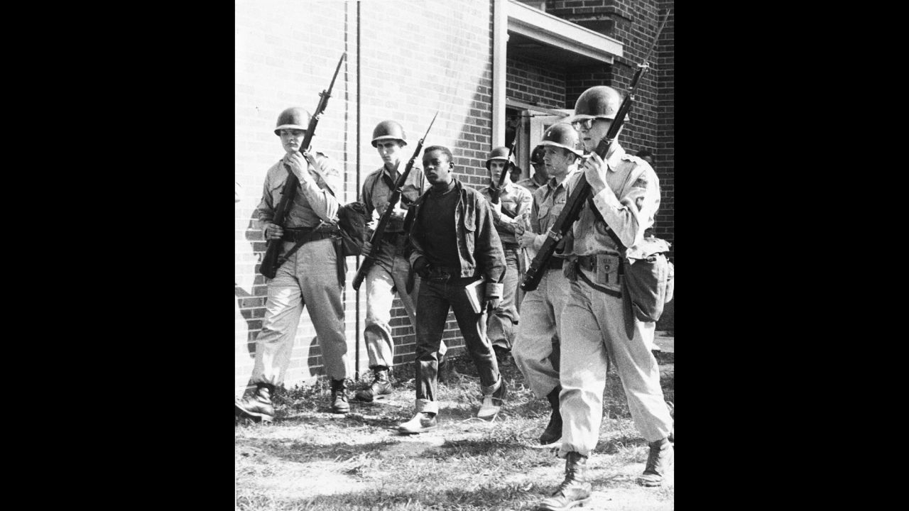 National Guardsmen escort a black student from high school in Sturgis, Kentucky, at the end of a school day in September 1956.