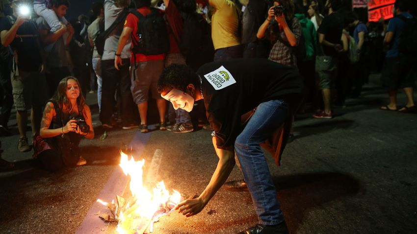 A masked demonstrator burns World Cup memorabilia at a protest against the upcoming 2014 World Cup on May 15, 2014 in Rio de Janeiro, Brazil.