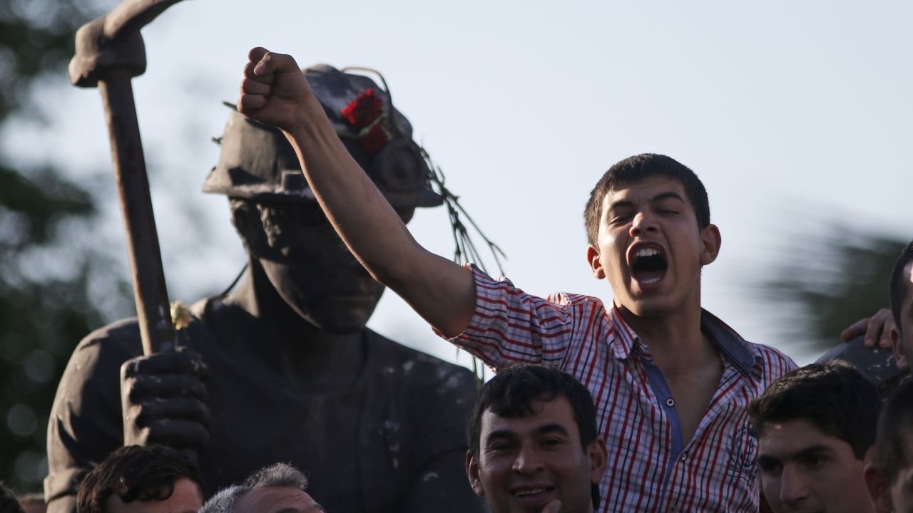 Anti-government protesters chant slogans on a monument for the town's miners, during a march in Soma, Turkey where the mine accident took place, Friday, May 16, 2014