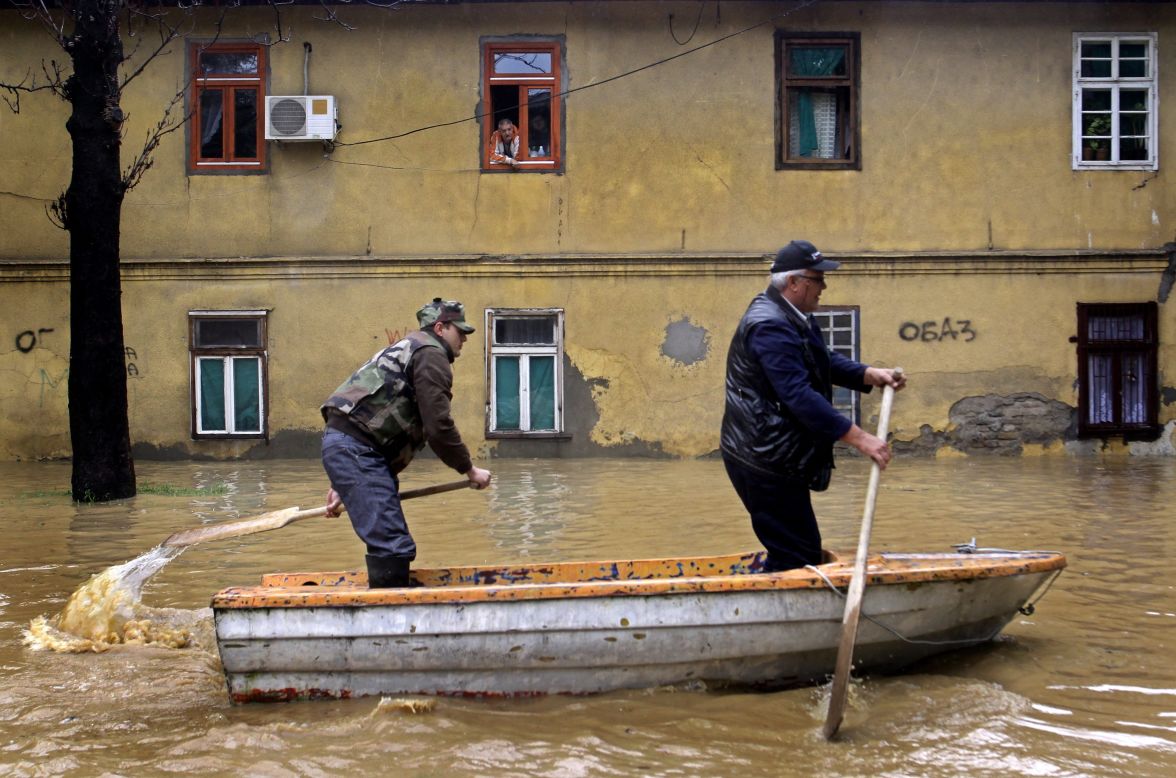 Men paddle through the flooded streets of Obrenovac on Friday, May 16. Authorities estimate that 90% of the town has been flooded.