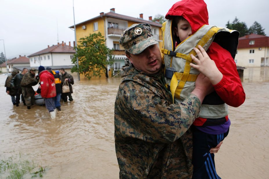 A member of the Bosnian army carries a boy rescued from his home May 16 in the town of Maglaj.