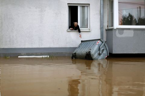 A woman tries to reach a trash container floating in the floodwaters in Obrenovac on May 16.