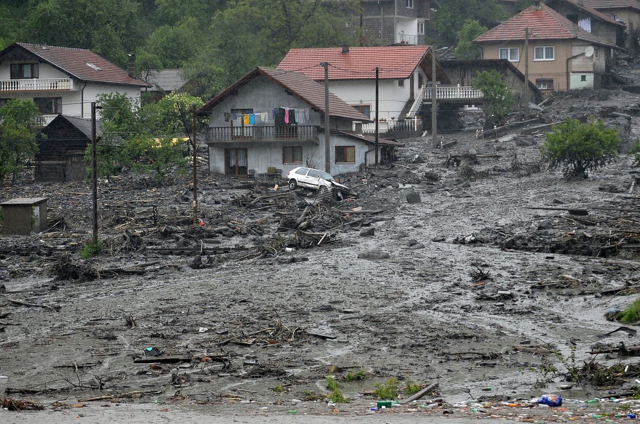 Landslide debris and floodwaters surround houses May 15 in the Bosnian village of Topcic Polje.