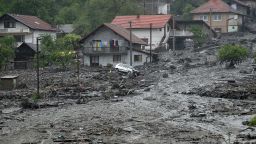 Debris from a landslide and floodwaters surround houses on May 15 in the village of Topcic Polje, near the Bosnian town of Zenica.