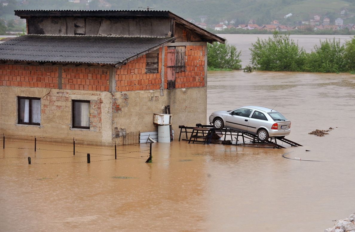 Floodwaters surround a car parked on a ramp Wednesday, May 14, in Doglodi, Bosnia-Herzegovina.