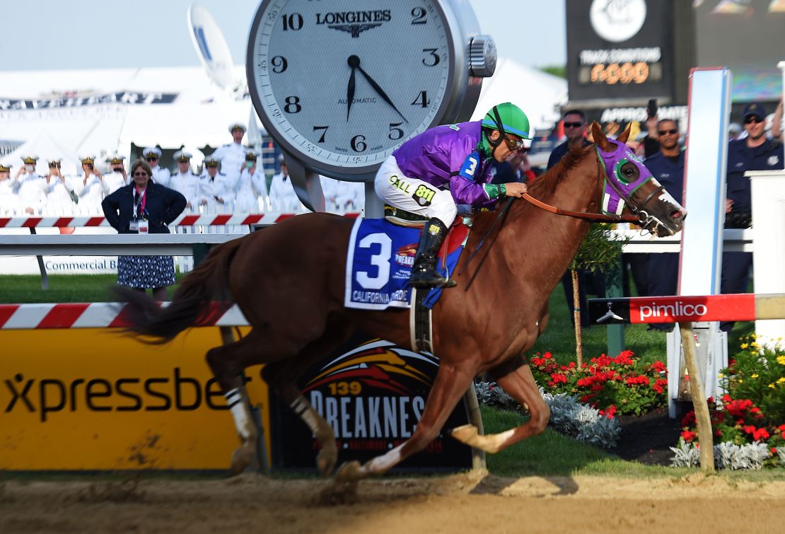 California Chrome, ridden by Victor Espinoza, crosses the finish line to win the  Preakness Stakes at Pimlico Race Course Saturday. 