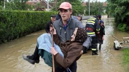 A Serbian rescuer carries an elderly woman out of her flooded house on May 17 in the village of Obrez, Serbia, south of Belgrade, on May 17.