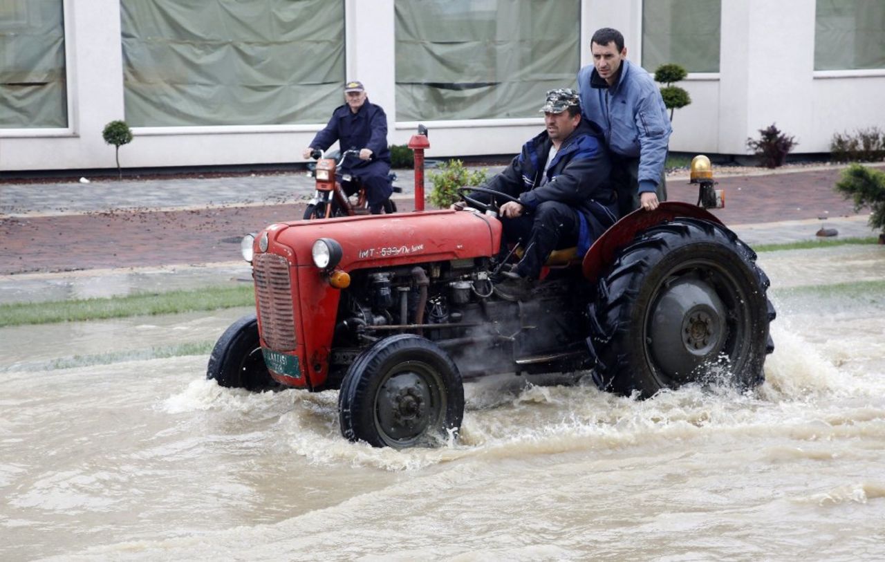 Bosnian men ride a tractor through flooded streets of Banja Luka on May 17.