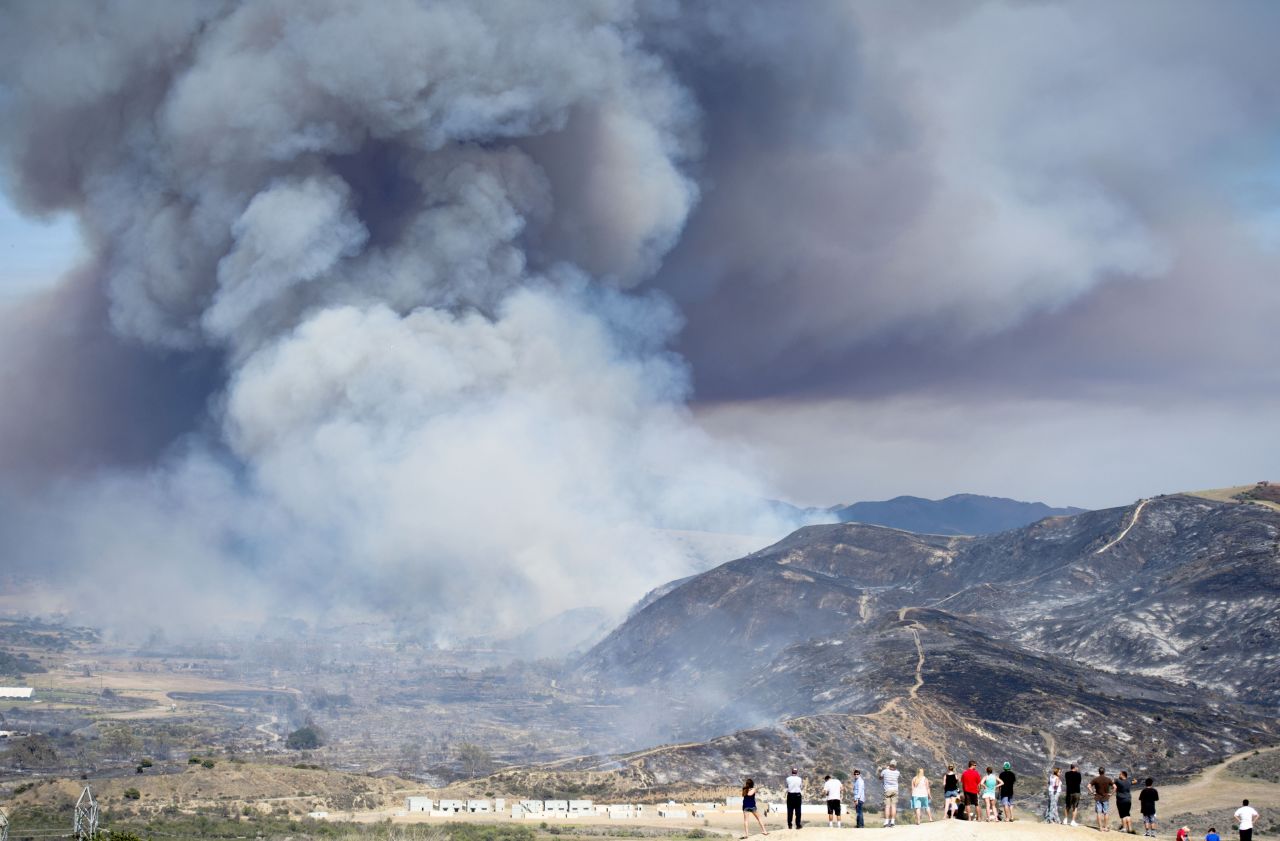 Residents watch a wildfire near San Diego on Friday, May 16. Wildfires devoured more than 20,000 acres in San Diego County after a high-pressure system brought unseasonable heat and gusty winds to the parched state.