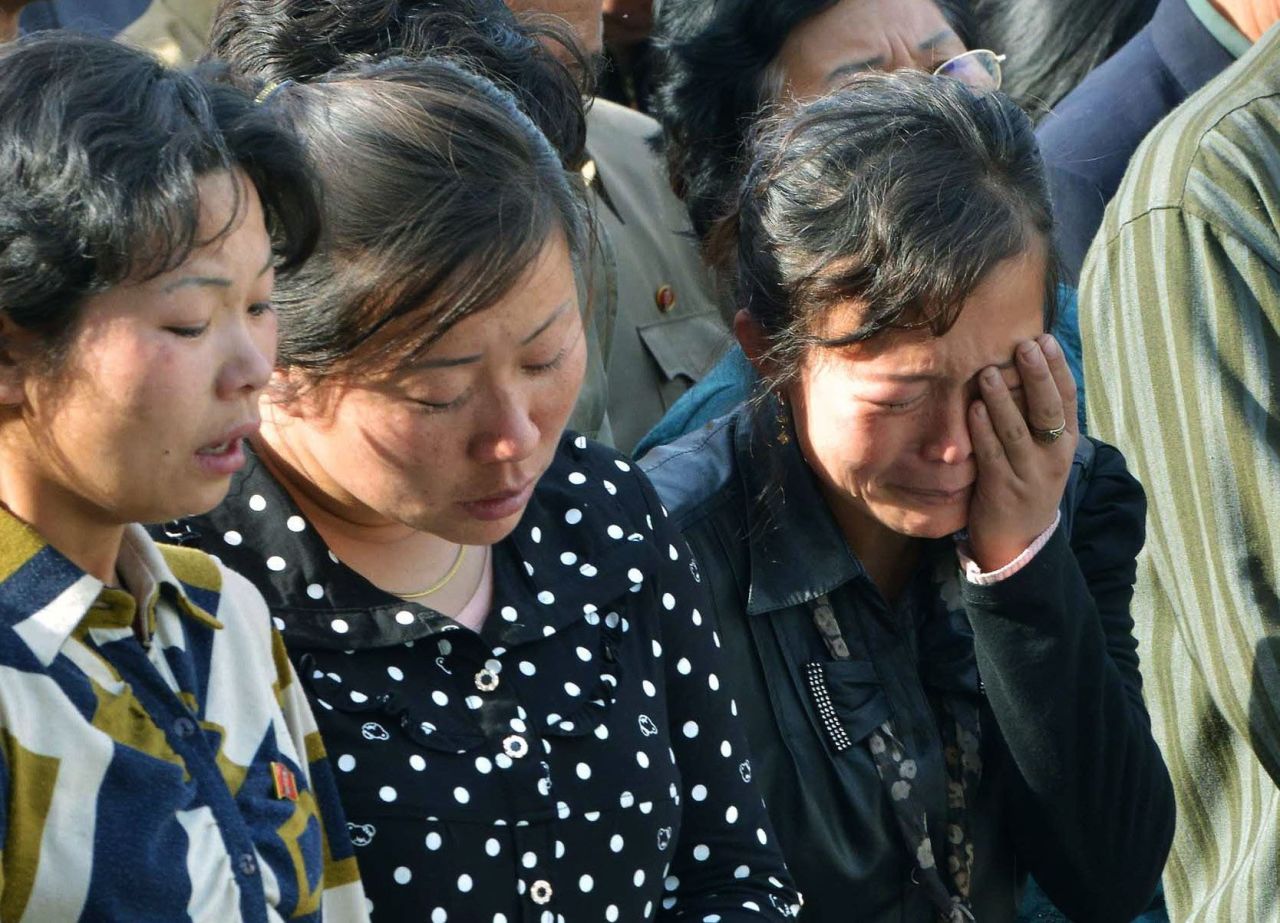 North Korean women listen as the official apologizes. 