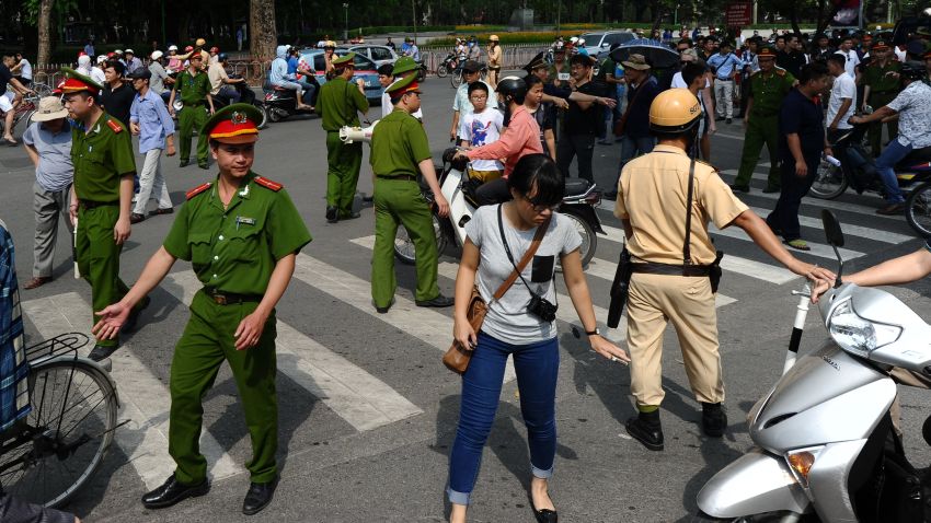 Caption:Policemen ask people to leave a street near to the Chinese embassy in Hanoi on May 18, 2014. A call for further anti-China protests appeared to have fizzled in the capital, with authorities deploying heavy security around the Chinese embassy and other suspected protest sites. AFP PHOTO/HOANG DINH Nam (Photo credit should read HOANG DINH NAM/AFP/Getty Images)