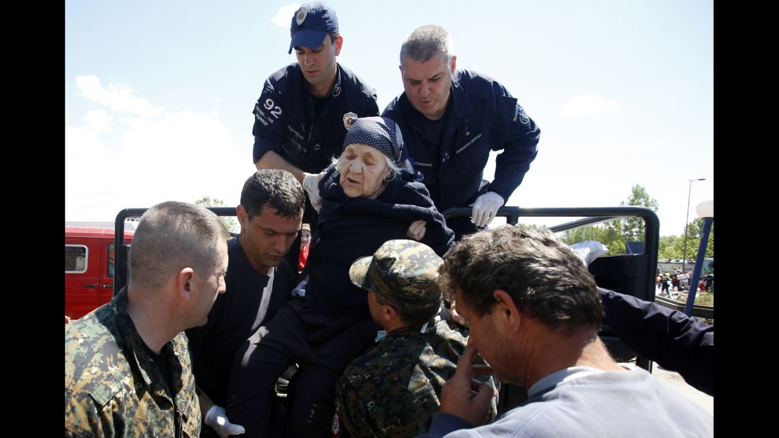 Police officers help an elderly women get out of a vehicle in Obrenovac on May 19.