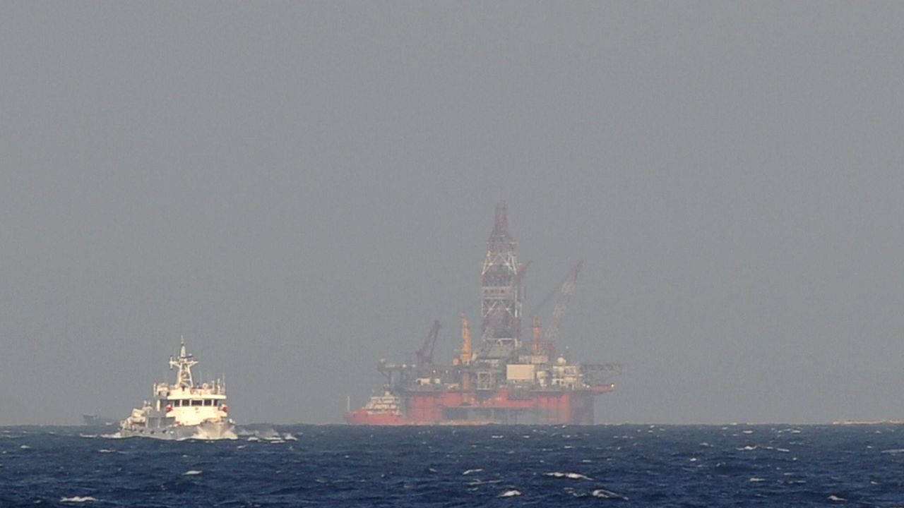 This picture taken on May 14, 2014 from a Vietnamese coast guard ship shows a Chinese coast guard vessel, left, sailing near China's oil drilling rig in disputed waters in the South China Sea. 
