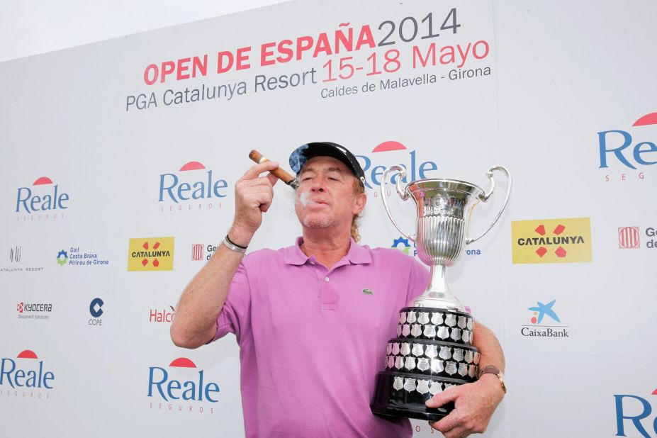With his trademark victory cigar in one hand, Miguel Angel Jimenez poses with the trophy in the other after winning his home Spanish Open for the first time on May 18, 2014. Having passed 50, he is the European Tour's oldest victor.