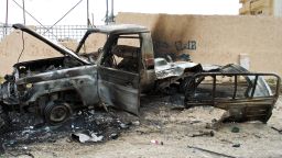 A burnt out vehicle is seen on the side of the road leading to the airport in Tripoli on May 19, 2014 following attacks by armed groups the previous day.