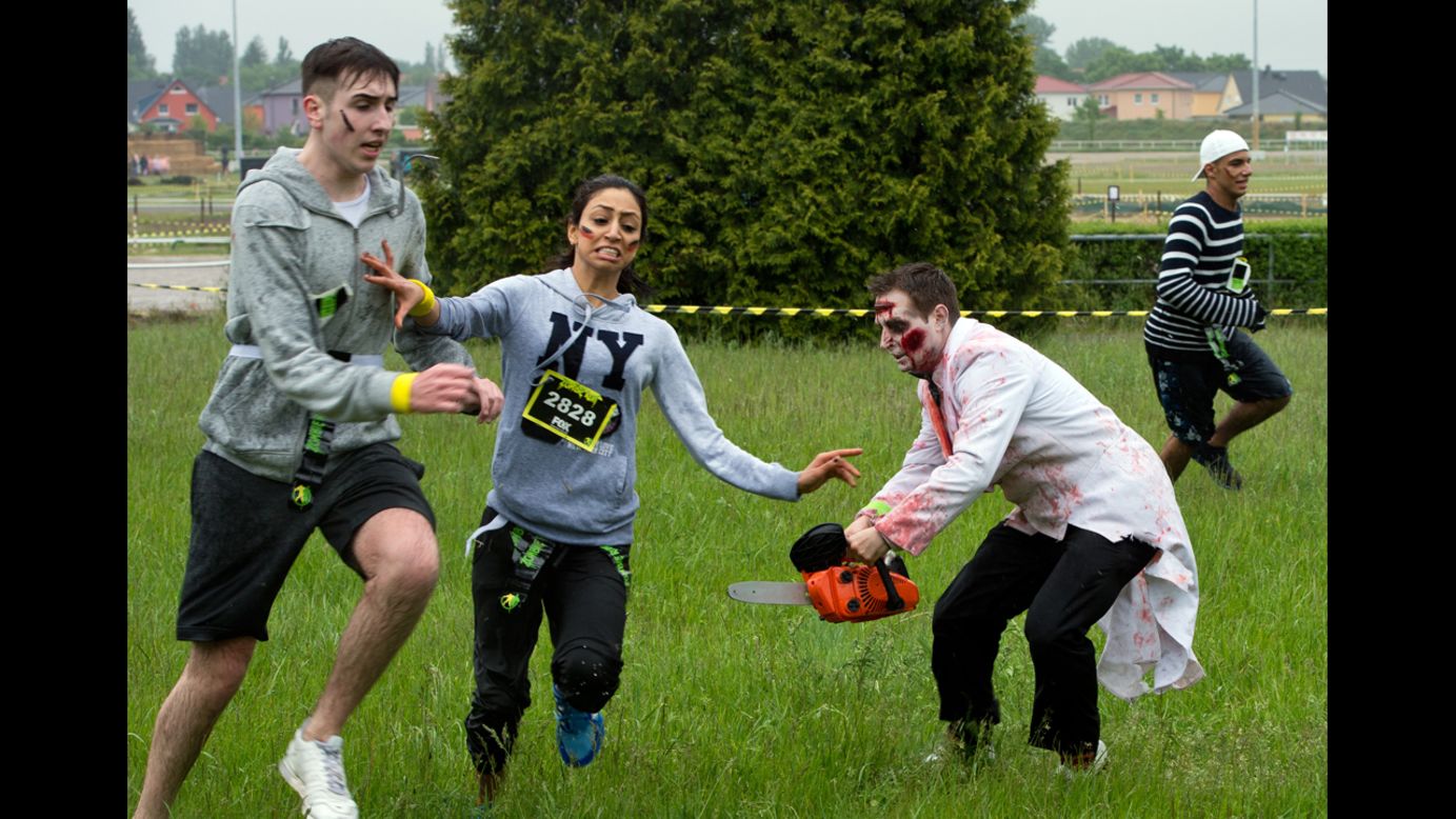 People dressed as zombies chase runners during the Zombie Run event Sunday, May 18, in Berlin. In the Zombie Run, which is based on the television series "The Walking Dead," runners have to avoid zombies and protect the small flags that are in their belts.