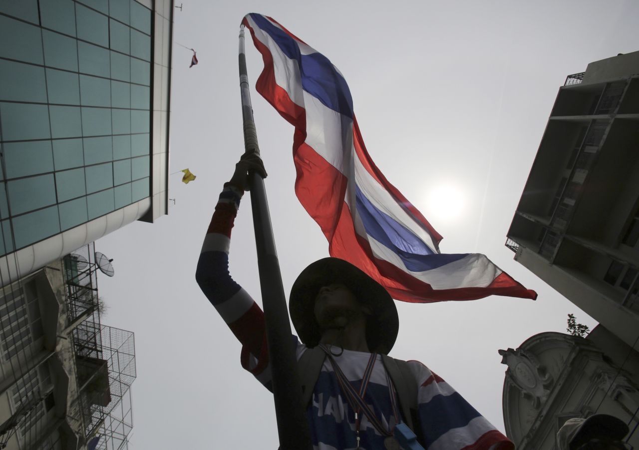 An anti-government protester waves a Thai national flag during a march through streets of Bangkok on Monday, May 19. Martial law went into effect at 3 a.m. the next morning.