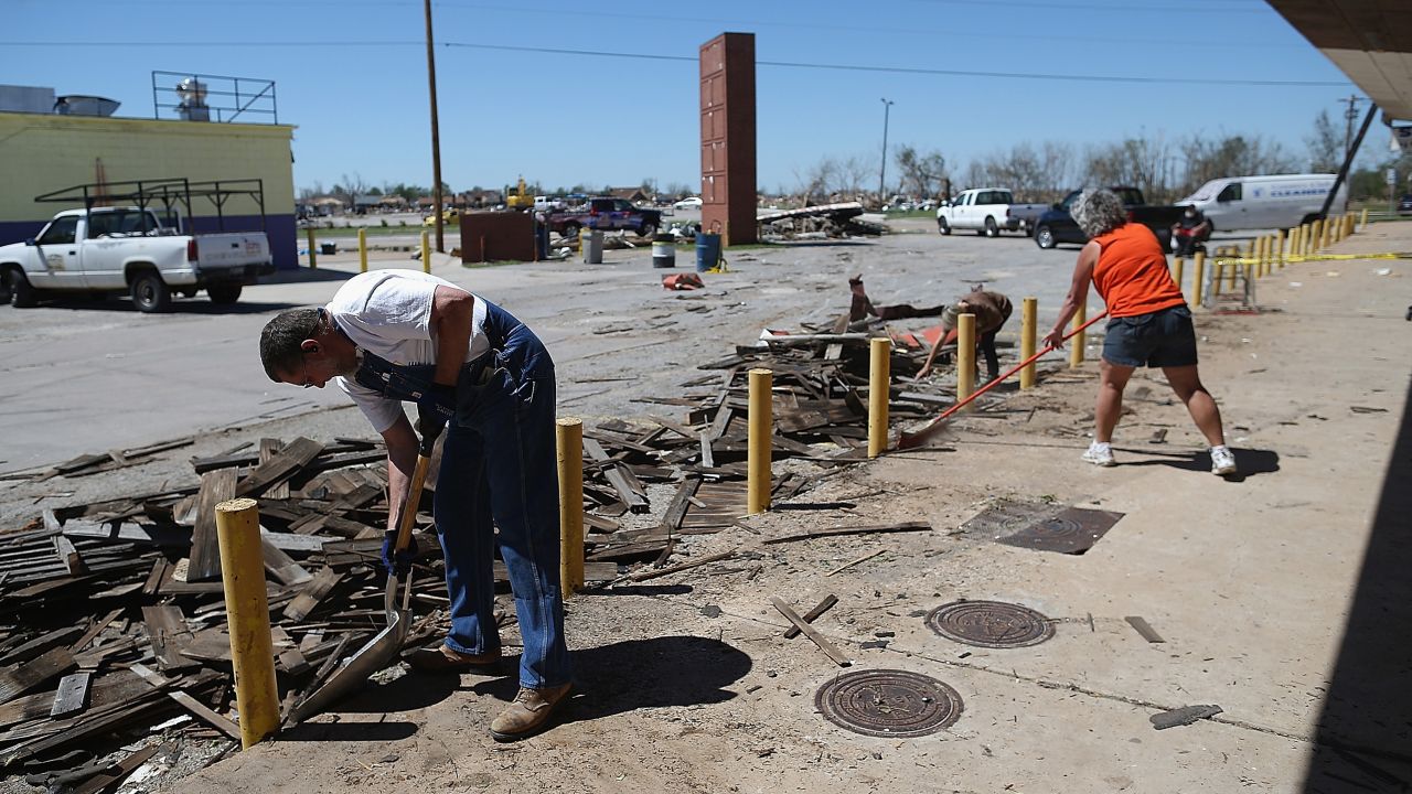 <strong>Then:</strong> Chuck Walker, left, cleans up debris near his shop at a strip mall on June 2, 2013.