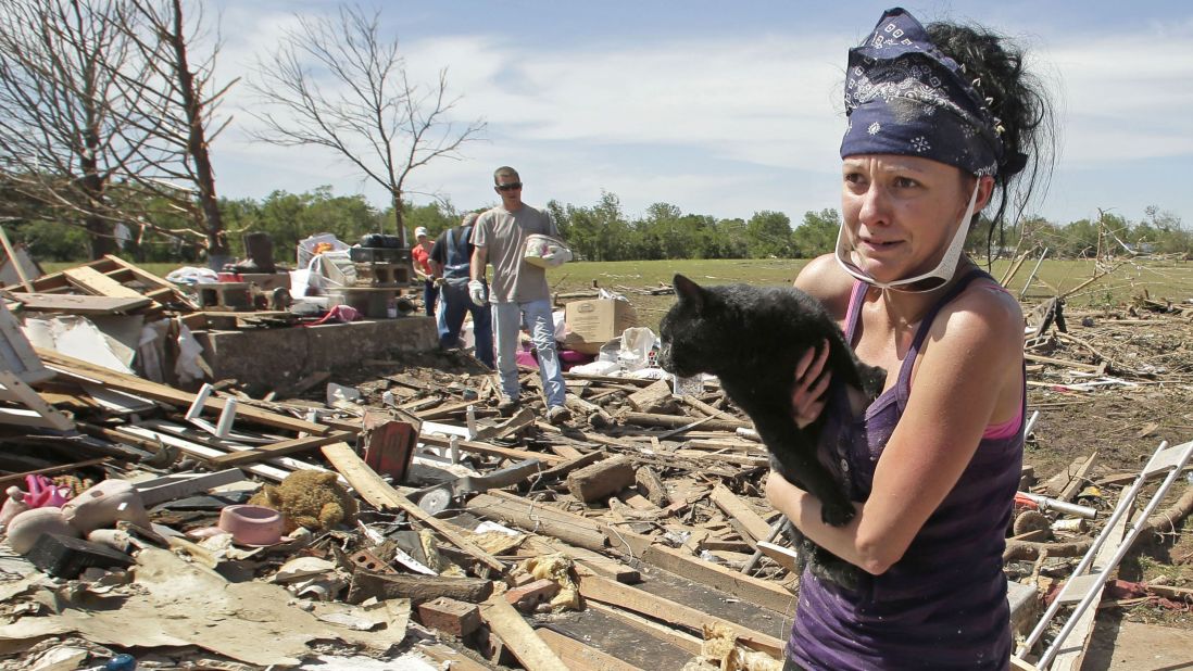 <strong>Then:</strong> Brittany Brown rushes to get aid after finding her grandmother's cat, Kitty, on May 22, 2013. The cat was buried in the rubble for two days.