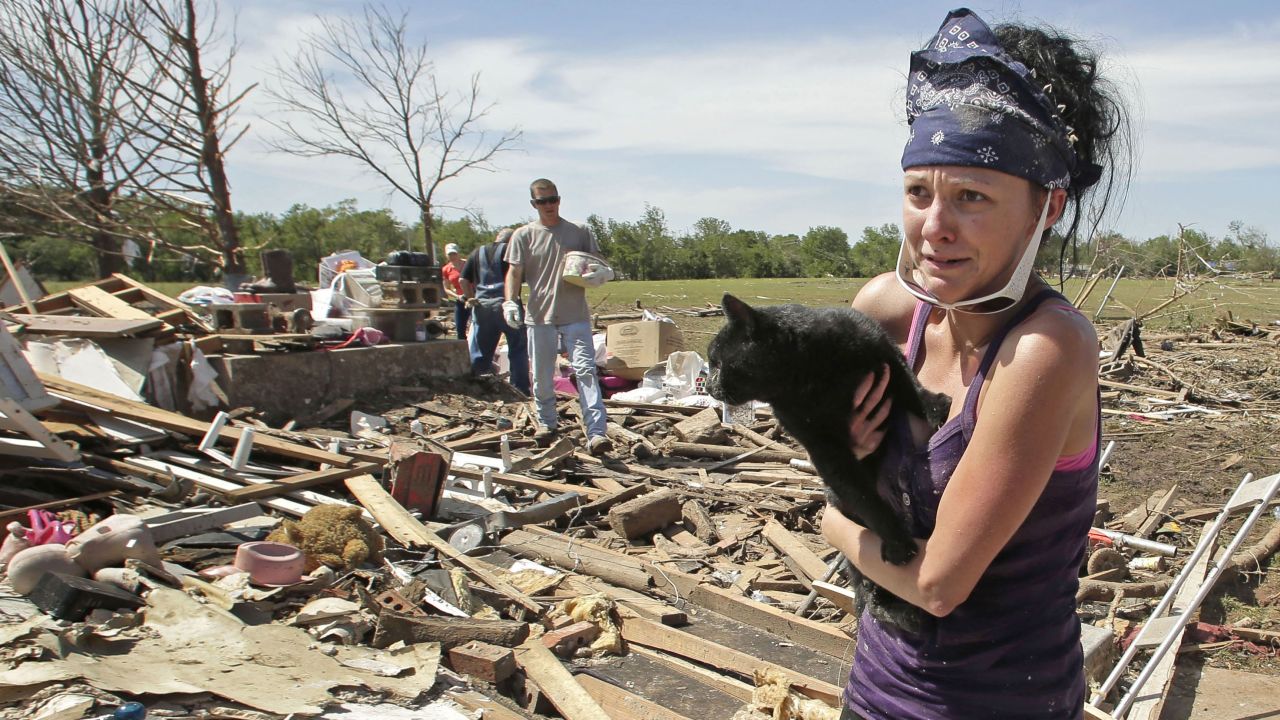 <strong>Then:</strong> Brittany Brown rushes to get aid after finding her grandmother's cat, Kitty, on May 22, 2013. The cat was buried in the rubble for two days.