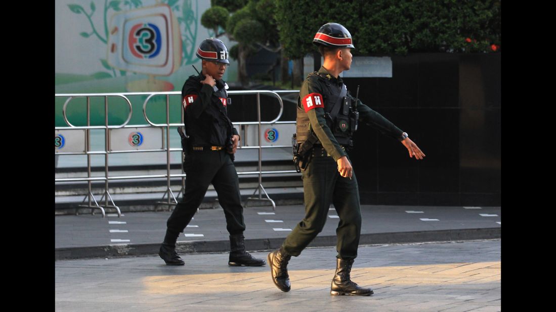 Military police officers walk in front of the Thai TV 3 offices in Bangkok on May 20. In a statement read on Thai television, the military declared that all of the country's radio and television stations must suspend their normal programs "when it is needed."