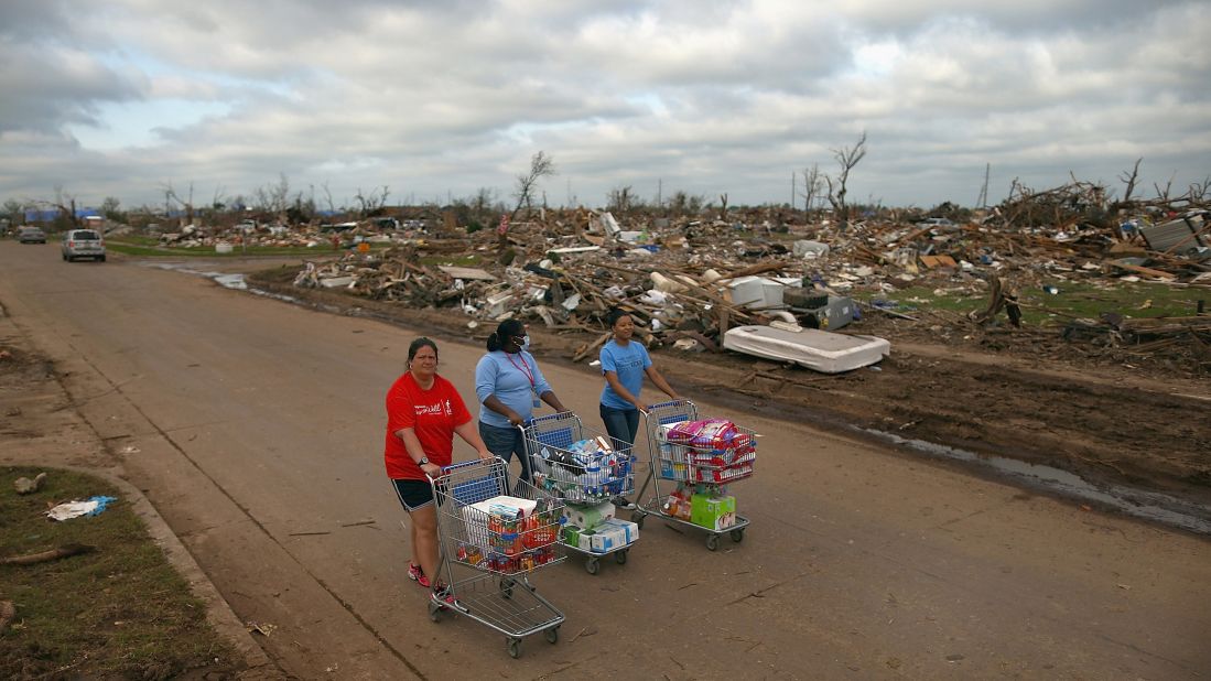 <strong>Then:</strong> From left, Jaqi Castro, Angelica Morris-Smith and Cetoria Petties walk through a tornado-ravaged neighborhood handing out supplies to residents and fellow volunteers on May 27, 2013.
