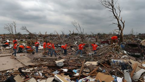 <strong>Then: </strong>Volunteers from several churches help a homeowner clear rubble from a destroyed neighborhood on May 24, 2013.