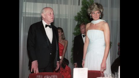 Princess Diana stands with British actor Alec Guinness in a demure blue dress and matching scarf at a Cannes gala dinner in 1987. The dress, by one of her favorite designers Catherine Walker, sold at auction for around $137, 000 in 2011. 