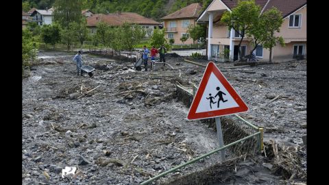 Residents clean streets of mud and rubble after a landslide in Topcic Polje, Bosnia-Herzegovina, on Tuesday, May 20.