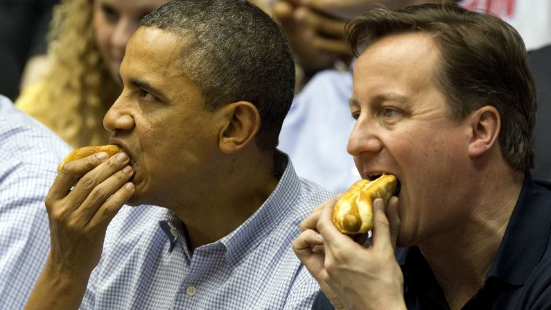 U.S. President Barack Obama and British Prime Minister David Cameron eat hot dogs in 2012 while watching a college basketball game in Dayton, Ohio.