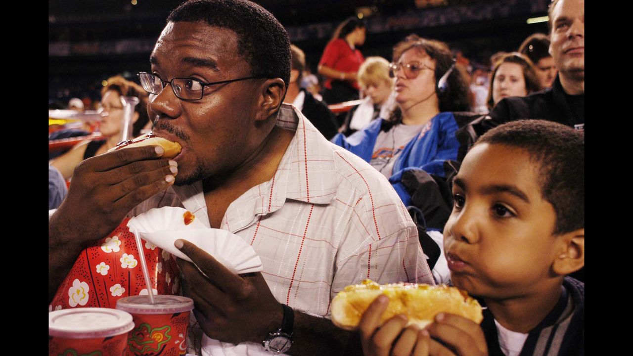 Baseball fans eat hot dogs during a game at New York's Shea Stadium in 2003.