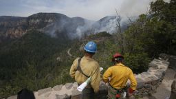 True Brown, left, of the Blue Ridge Hotshots, and Mark Adams of the Mormon Lake Hotshots take a high vantage point as spotters for those fighting a wildfire near Flagstaff, Arizona, on Friday, May 23.