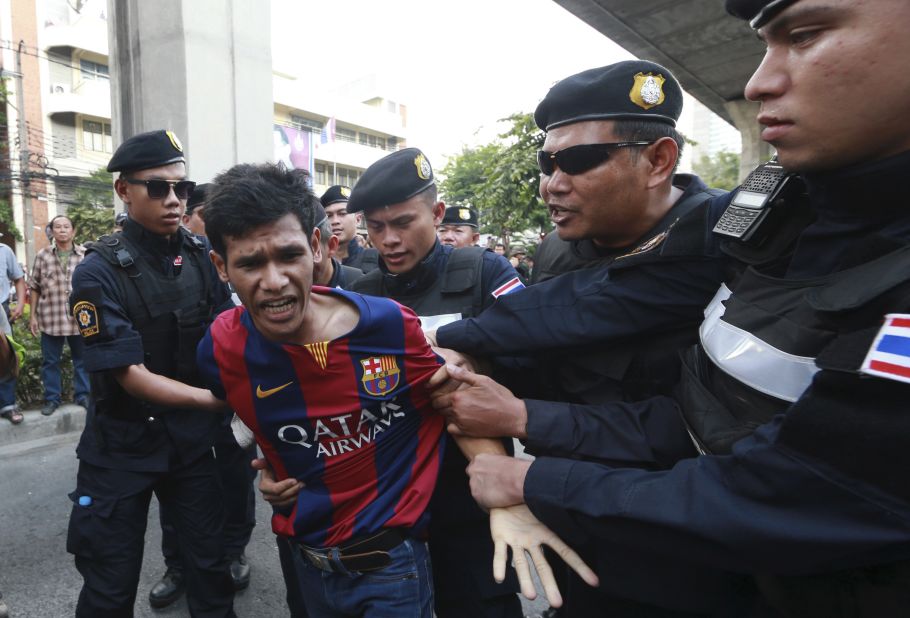 An anti-coup protester is detained by Thai police officers during a protest in Bangkok on Saturday, May 24. 