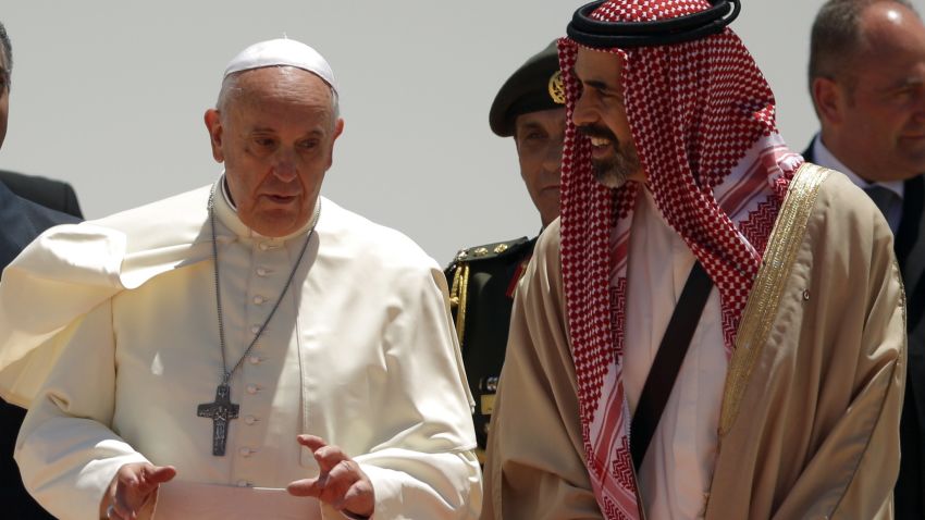 Caption:Pope Francis (L) is greeted by Jordans Prince Ghazi bin Mohammed (R), King Abdullah II's religious affairs adviser, upon his arrival at Marka International Airport in Amman on May 24, 2014. Pope Francis arrived in Jordan for the first leg of a Middle East tour aimed at bettering relations with Jews and Muslims as well as easing an ancient rift within Christianity. AFP PHOTO / PATRICK BAZ (Photo credit should read PATRICK BAZ/AFP/Getty Images)