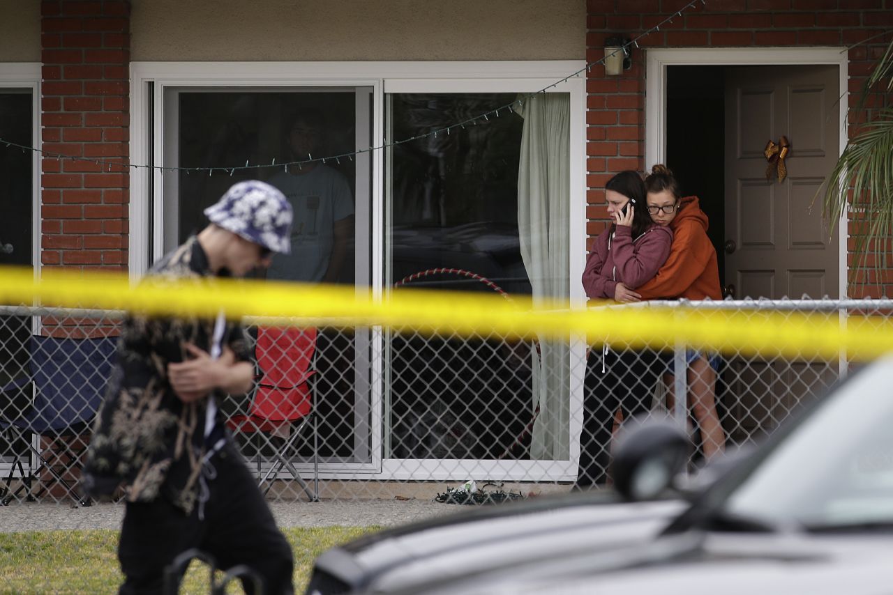 Two women comfort each other Saturday near the scene of a shooting. Seven people also were being treated in a hospital for gunshot wounds or traumatic injuries, a sheriff's office spokeswoman said.