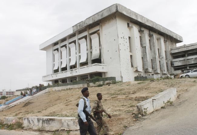Somali army soldiers walk next to the parliament building after the attack. 