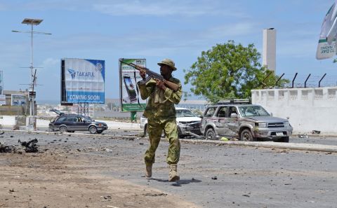 An armed Somali soldier runs to fight during an attack on the parliament in Mogadishu, Saturday, May 24. Al-Shabaab militants launched the attack using automatic weapons and explosives, leaving several dead and wounded, according to witnesses and officials.