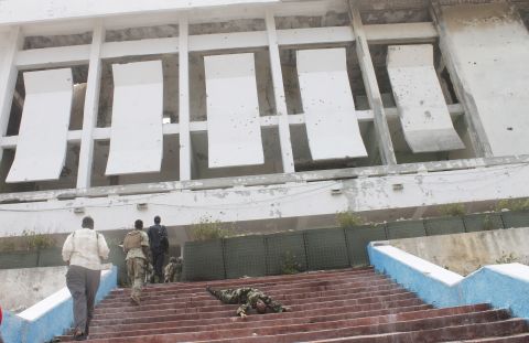 Somali army soldiers walk next to the body of a comrade in front of the parliament building after the attack.