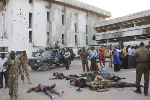 People gather around the bodies of combatants after the attack. 