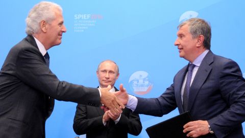 Putin behind Igor Sechin (R), the CEO of Rosneft, and Marco Tronchetti Provera of Italian tire manufacturer Pirelli.  