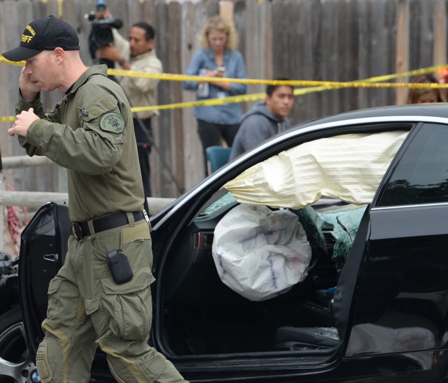 An investigator speaks on a cell phone while examining the gunman's car.