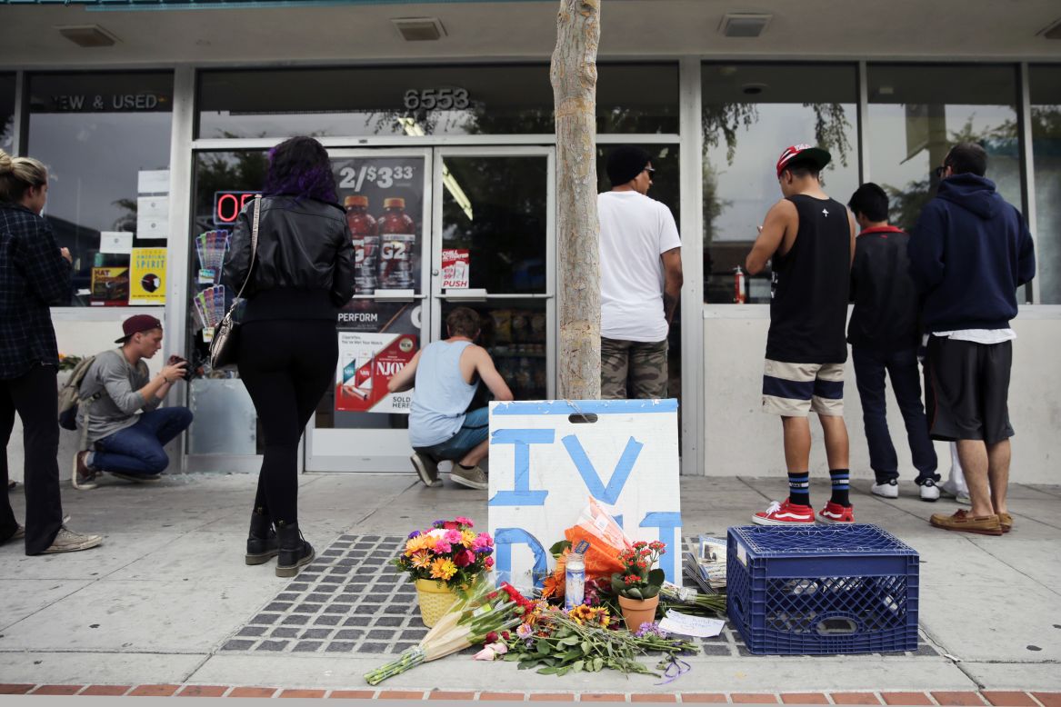 Flowers are left on the sidewalk of the IV Deli Mart in Isla Vista, California. 