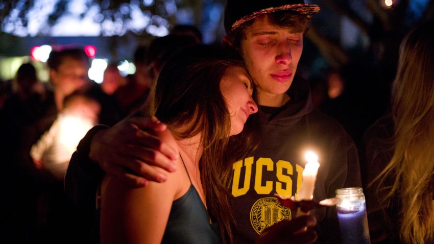 Two students comfort each other during a candlelight vigil held to honor the victims of Friday night's mass shooting in Isla Vista, California, on Saturday, May 24. Sheriff's officials say Elliot Rodger, 22, went on a rampage near the University of California, Santa Barbara, stabbing three people to death at his apartment before shooting and killing three more in a crime spree through a nearby neighborhood.