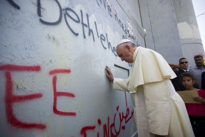 Francis touches the wall that divides Israel from the West Bank on his way to celebrate a Mass in Bethlehem on May 25.