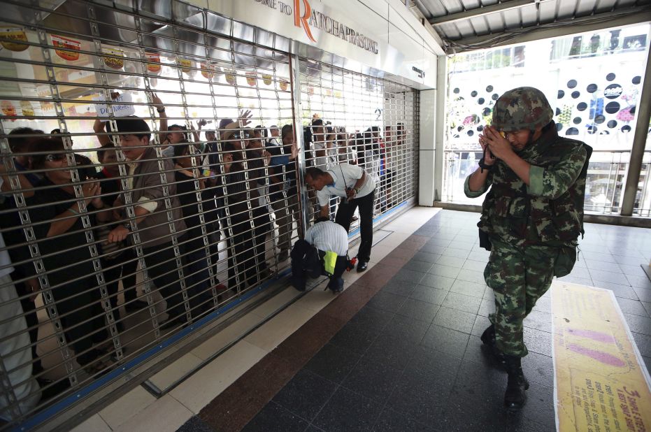 A Thai soldier, citing safety reasons, apologies to pedestrians after he closes the fence to an overpass during an anti-coup demonstration in Bangkok on May 25.