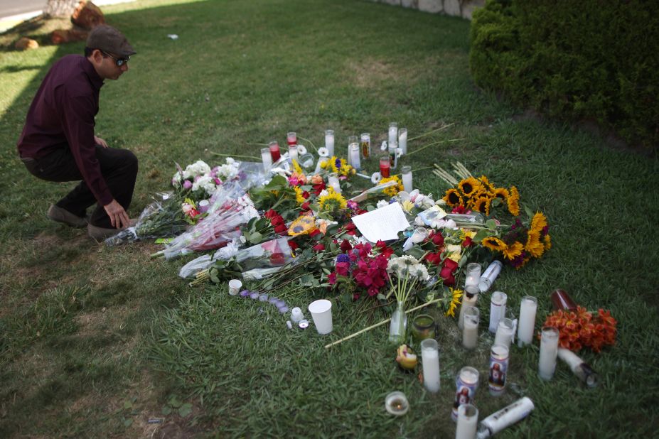 A man places flowers on the lawn of the Alpha Phi sorority house in Isla Vista on May 25. Two young women -- Katherine Cooper, 22, and Veronika Weiss, 19, -- were fatally shot outside the house Friday night.