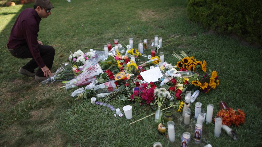  A man places flowers on the lawn of the Alpha Phi sorority house May 25, 2014 in Isla Vista, California.