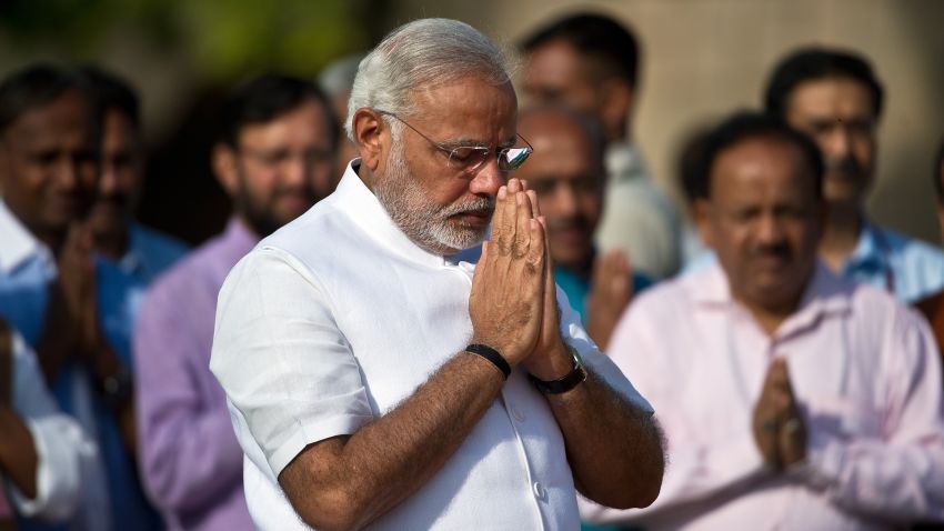 India Prime Minister Designate Narendra Modi (C) gestures as he pays tributes at Rajghat, memorial of Mahatama Gandhi in New Delhi on May 26, 2014.Hindu nationalist Narendra Modi will be sworn in as India's new prime minister on May 26 in a ceremony to be attended by arch rival Pakistan's premier for the first time in the two nations' history. The 63-year-old hardliner won a landslide election victory, handing him a powerful mandate to revive India's stagnant economy and implement more assertive foreign policy after 10 years of left-leaning Congress party rule. AFP PHOTO/Prakash SINGH (Photo credit should read PRAKASH SINGH/AFP/Getty Images)